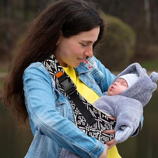 Écharpe de portage bandoulière maman regarde bébé tendrement